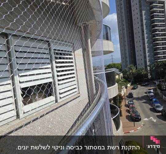 רשת יונים מותקנת על מרפסת בניין גבוה